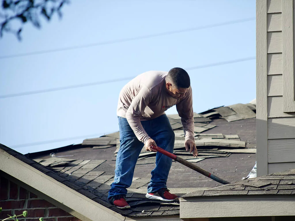 Roofer installing shingles on a residential roof